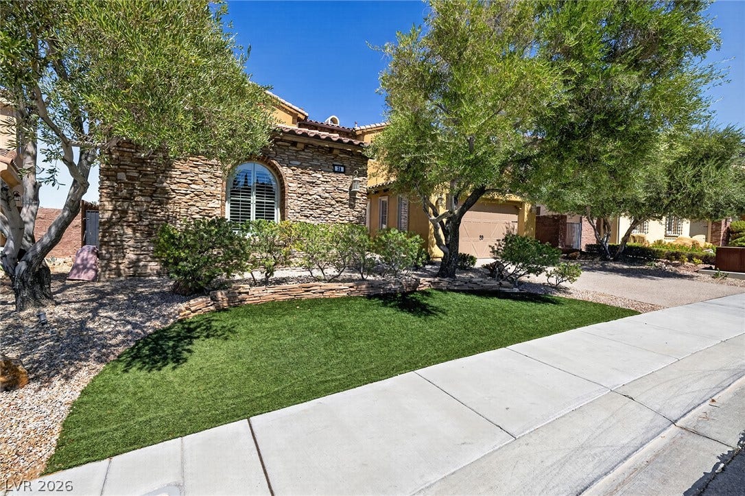 30 Benevolo Drive, Henderson, NV 89011 A well-manicured front yard with artificial turf complements the stone and stucco facade of this charming residence.