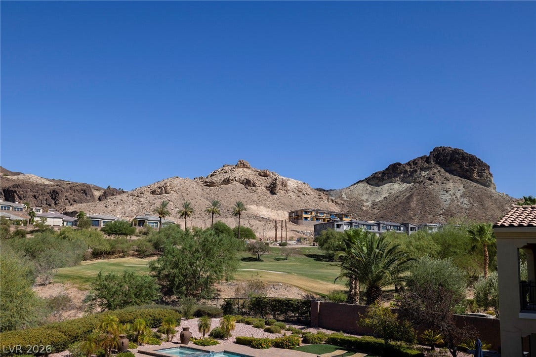 30 Benevolo Drive, Henderson, NV 89011 A desert oasis with panoramic views of the rugged mountains, golf course, and distant homes.