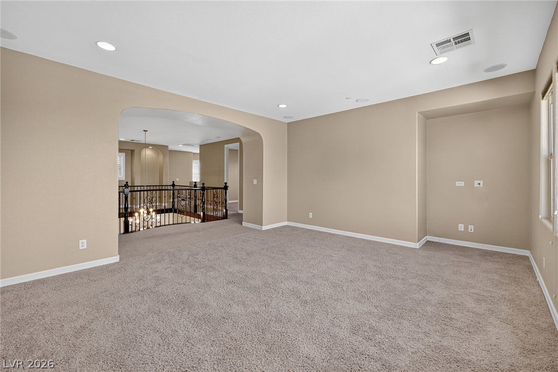 30 Benevolo Drive, Henderson, NV 89011 A spacious, naturally illuminated room featuring an elegant wrought iron railing overlooking the lower level.