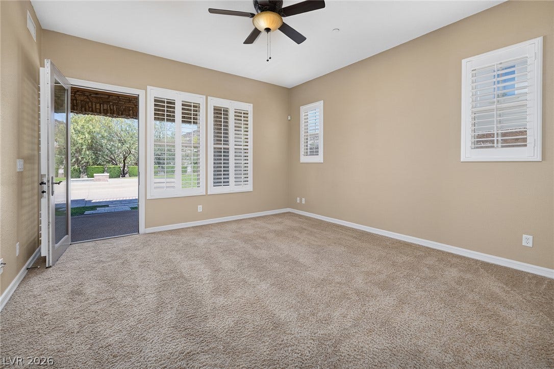30 Benevolo Drive, Henderson, NV 89011 A well-lit bedroom features plush carpeting, elegant window shutters, and a convenient exterior door leading to a private patio.