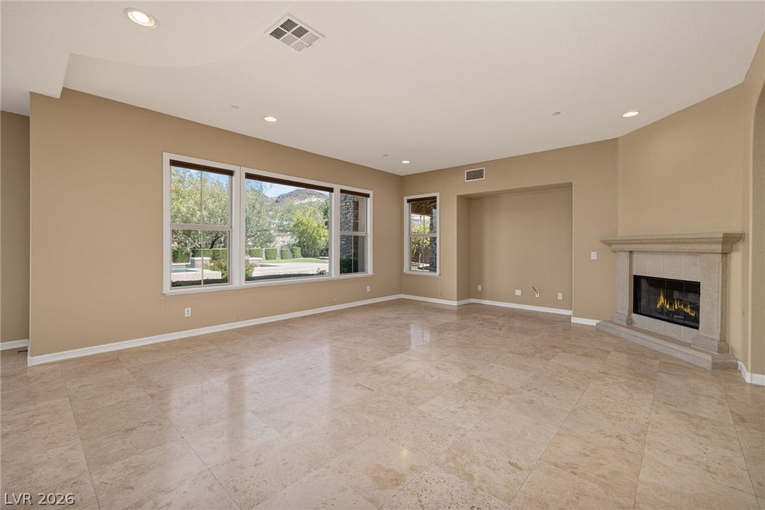 30 Benevolo Drive, Henderson, NV 89011 A naturally illuminated living area features sleek tile flooring, a sophisticated stone fireplace, and ample natural light.
