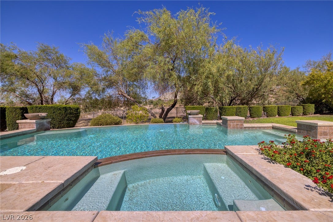 30 Benevolo Drive, Henderson, NV 89011 A tranquil oasis awaits with this sparkling pool and integrated spa, framed by lush landscaping and mature trees.