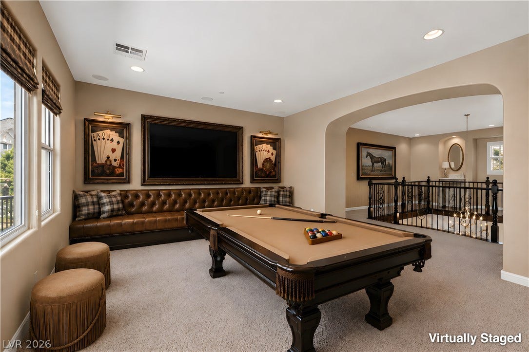 30 Benevolo Drive, Henderson, NV 89011 An inviting game room complete with a billiards table, built-in seating, and a grand archway leading to a stately staircase.