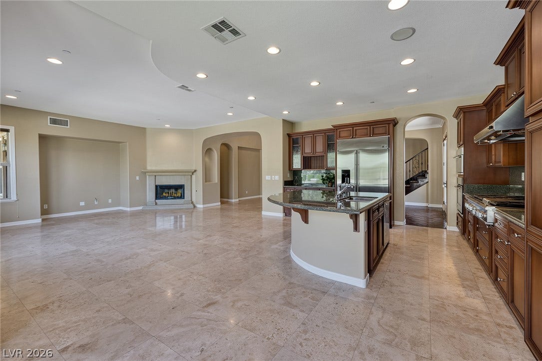 30 Benevolo Drive, Henderson, NV 89011 An open-concept living space with a gourmet kitchen and a cozy fireplace, perfect for entertaining.
