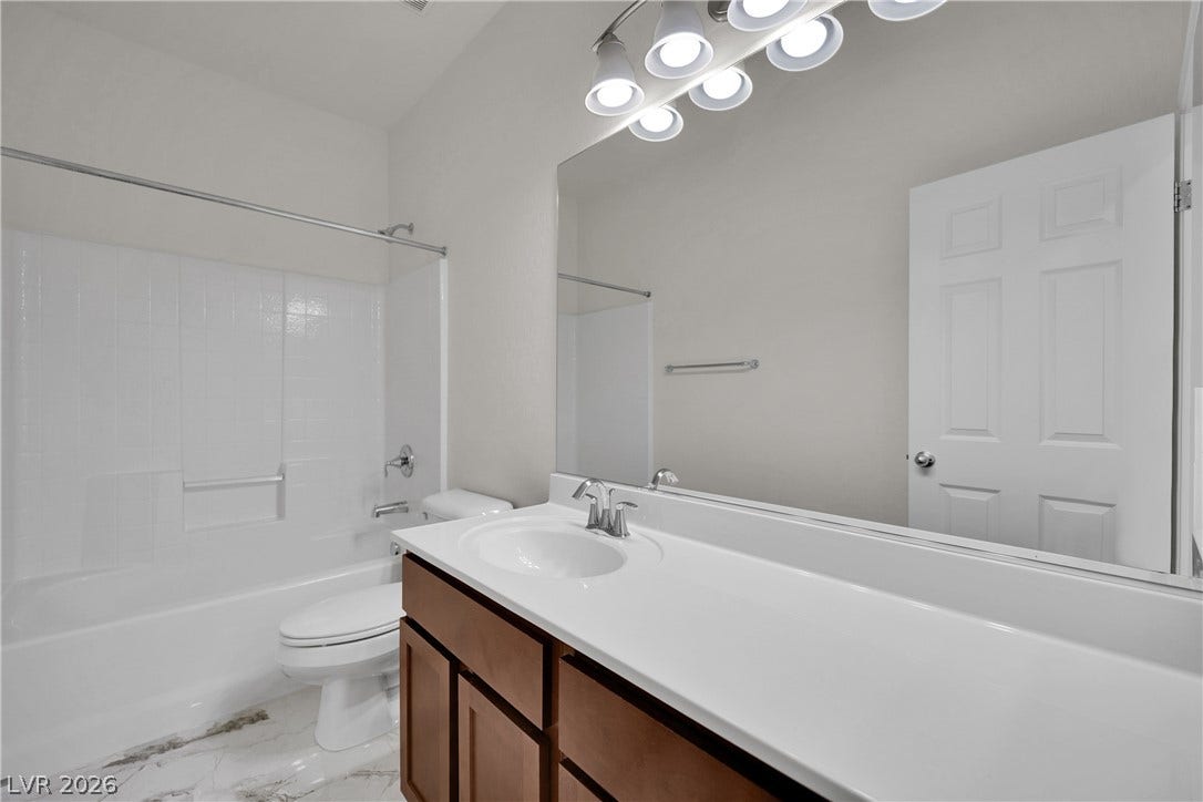 771 White Dogwood Court, Las Vegas, NV 89148 Modern downstairs full bath features a single vanity, a spacious mirror, and a combined shower-bathtub unit.
