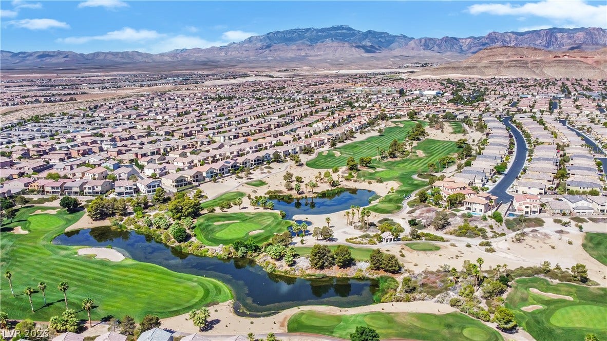 771 White Dogwood Court, Las Vegas, NV 89148 An aerial perspective reveals a vibrant golf course community nestled against distant mountains.