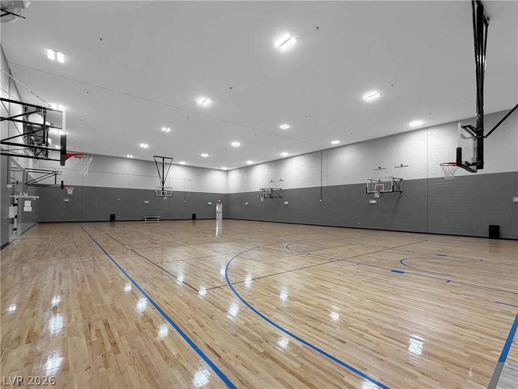 771 White Dogwood Court, Las Vegas, NV 89148 An indoor basketball court features sleek hardwood floors and multiple hoops for active recreation.