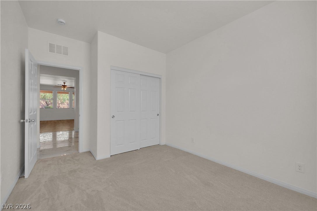 771 White Dogwood Court, Las Vegas, NV 89148 An inviting downstairs room boasts fresh, clean carpeting and a practical bi-fold closet, offering comfortable living space.