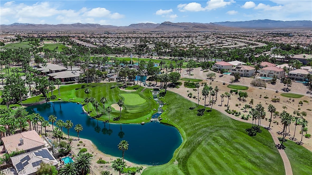 771 White Dogwood Court, Las Vegas, NV 89148 An aerial panorama showcases a meticulously landscaped golf course winding through a residential community with sparkling lakes.
