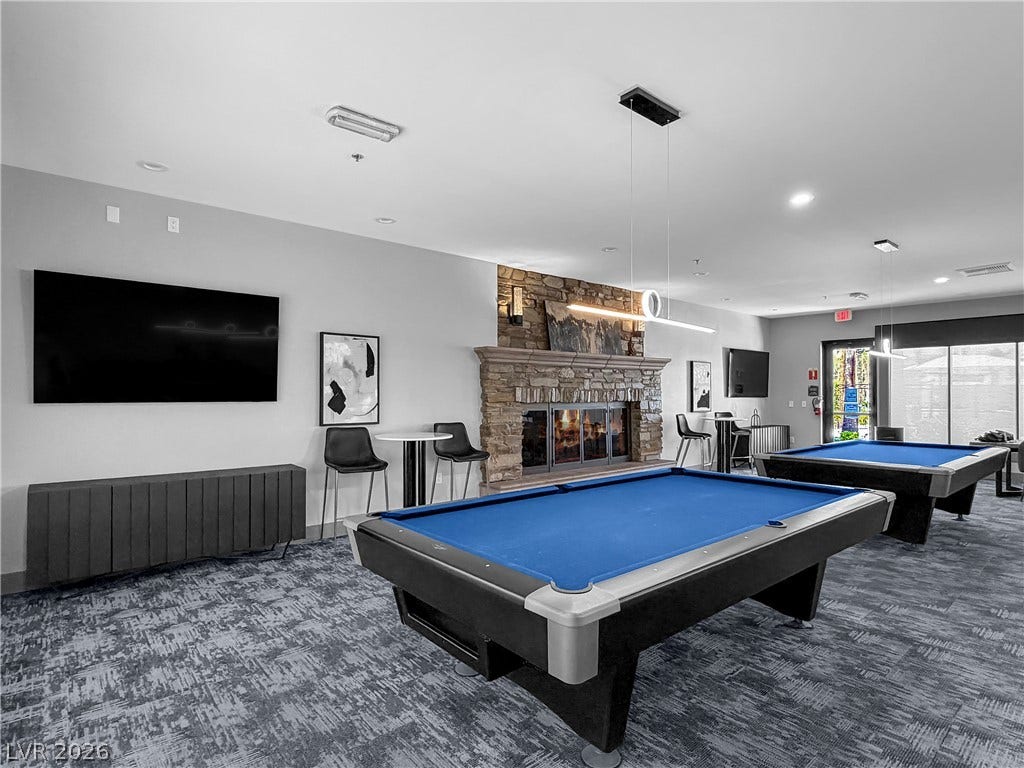 771 White Dogwood Court, Las Vegas, NV 89148 A well-appointed game room features dual pool tables and a striking stone fireplace.