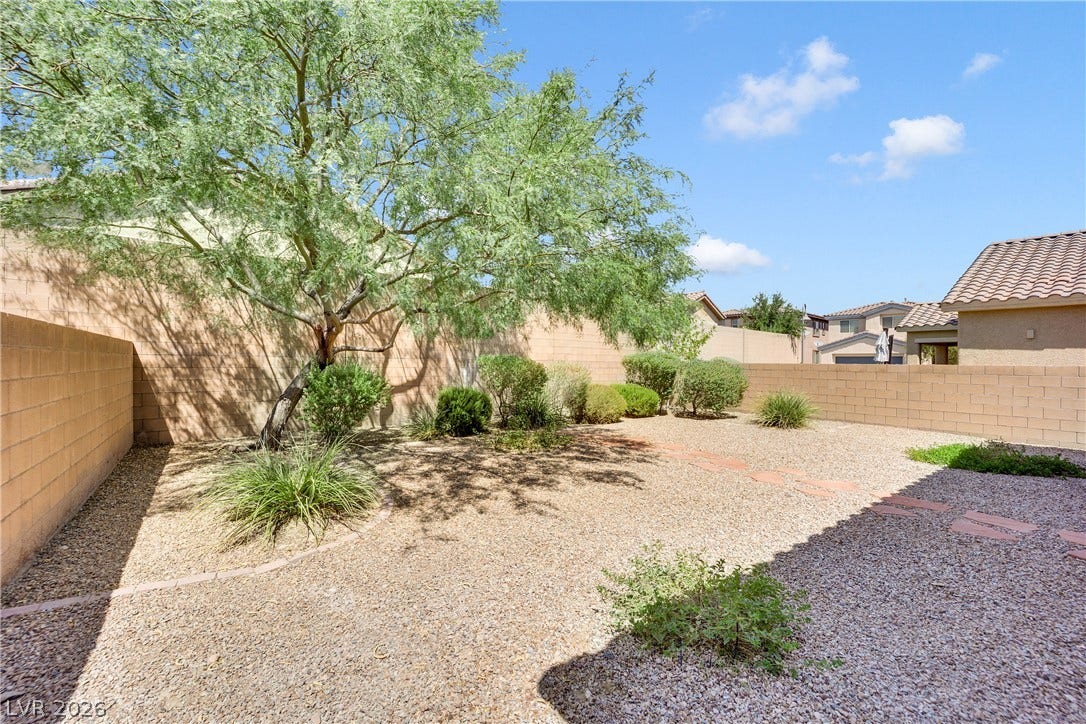 771 White Dogwood Court, Las Vegas, NV 89148 A low-maintenance desert landscape with a thriving shade tree provides a private outdoor retreat.