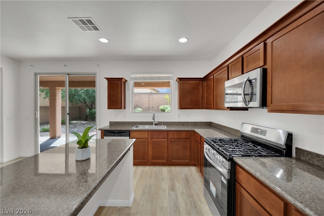 771 White Dogwood Court, Las Vegas, NV 89148 Classic wooden cabinetry and polished granite countertops define this functional culinary space.