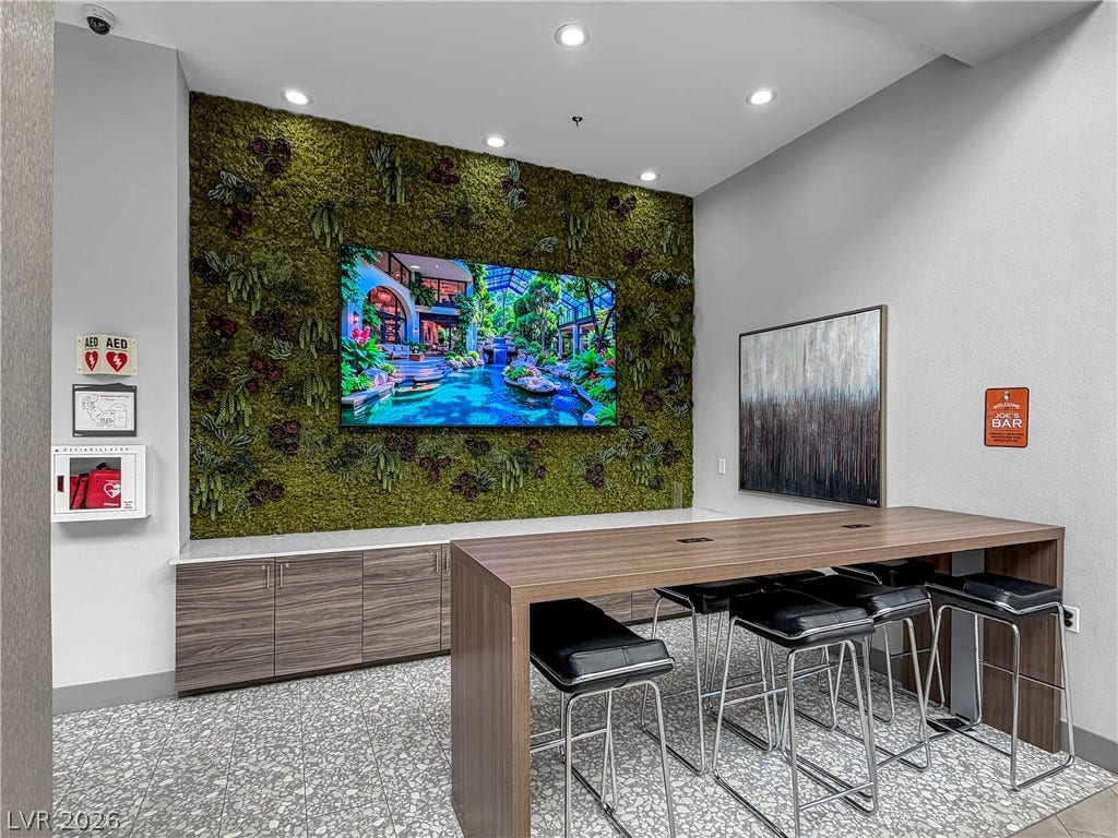 771 White Dogwood Court, Las Vegas, NV 89148 An inviting social hub with a verdant feature wall and bar seating perfect for gatherings.