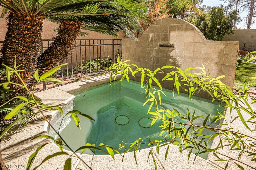 1828 Dolce Drive, Las Vegas, NV 89134 A tranquil spa with a cascading water feature, surrounded by lush foliage.