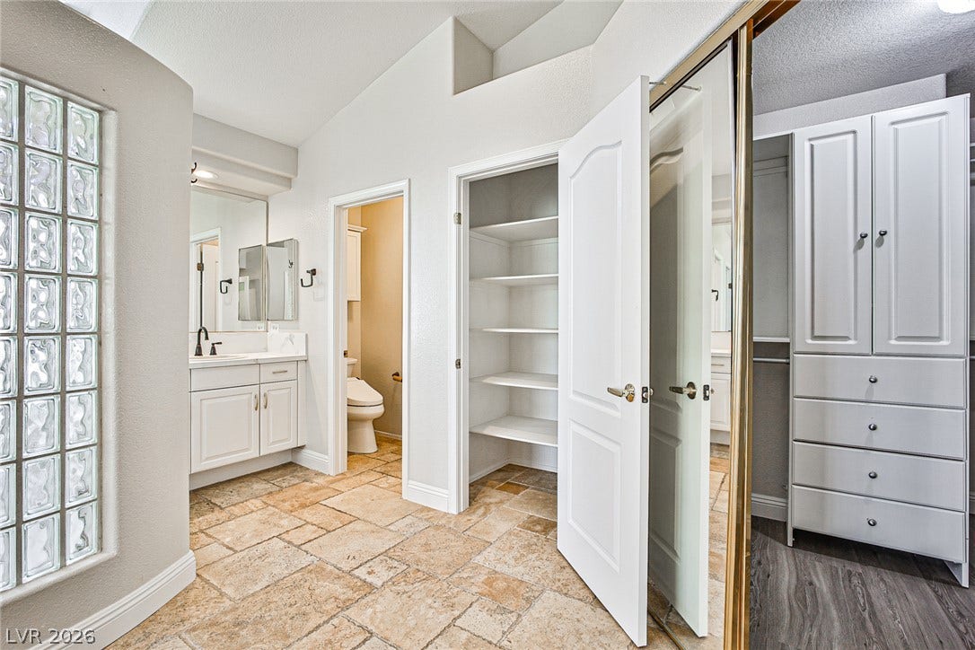 1828 Dolce Drive, Las Vegas, NV 89134 Ample storage solutions and dual vanities enhance this well-appointed private bathroom.