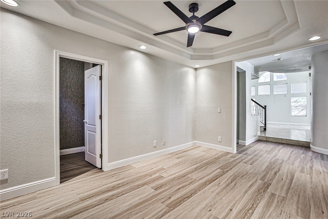 1828 Dolce Drive, Las Vegas, NV 89134 Recessed lighting illuminates this versatile space, featuring plank flooring and a stylish tray ceiling.