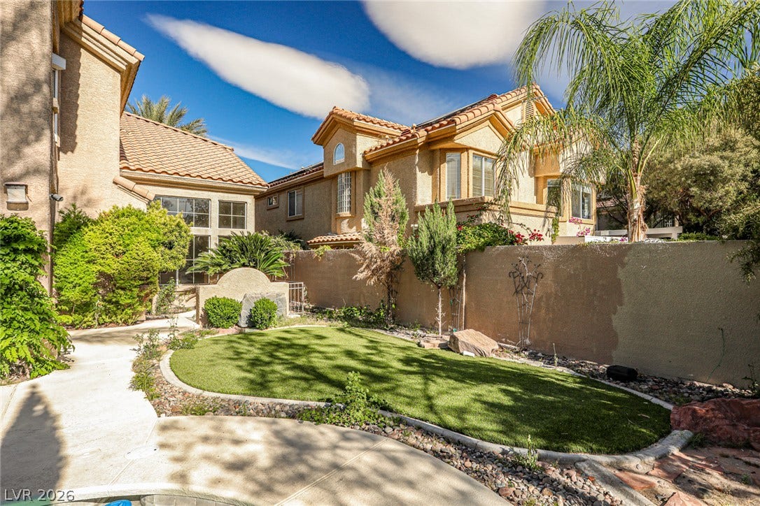 1828 Dolce Drive, Las Vegas, NV 89134 A well-maintained yard offers lush green turf and vibrant landscaping, creating a serene outdoor escape.