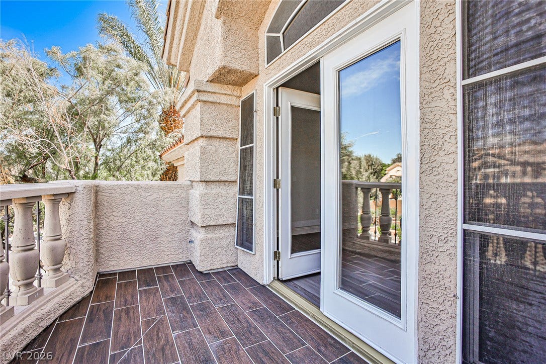 1828 Dolce Drive, Las Vegas, NV 89134 An inviting private balcony offers a serene outdoor retreat with a view of mature trees and open skies.