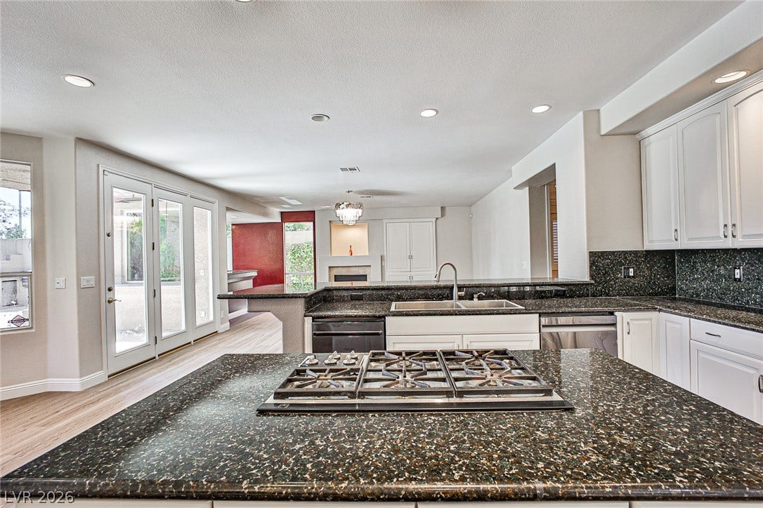 1828 Dolce Drive, Las Vegas, NV 89134 A well-lit kitchen with sleek countertops flows into an open-concept living area with outdoor access.