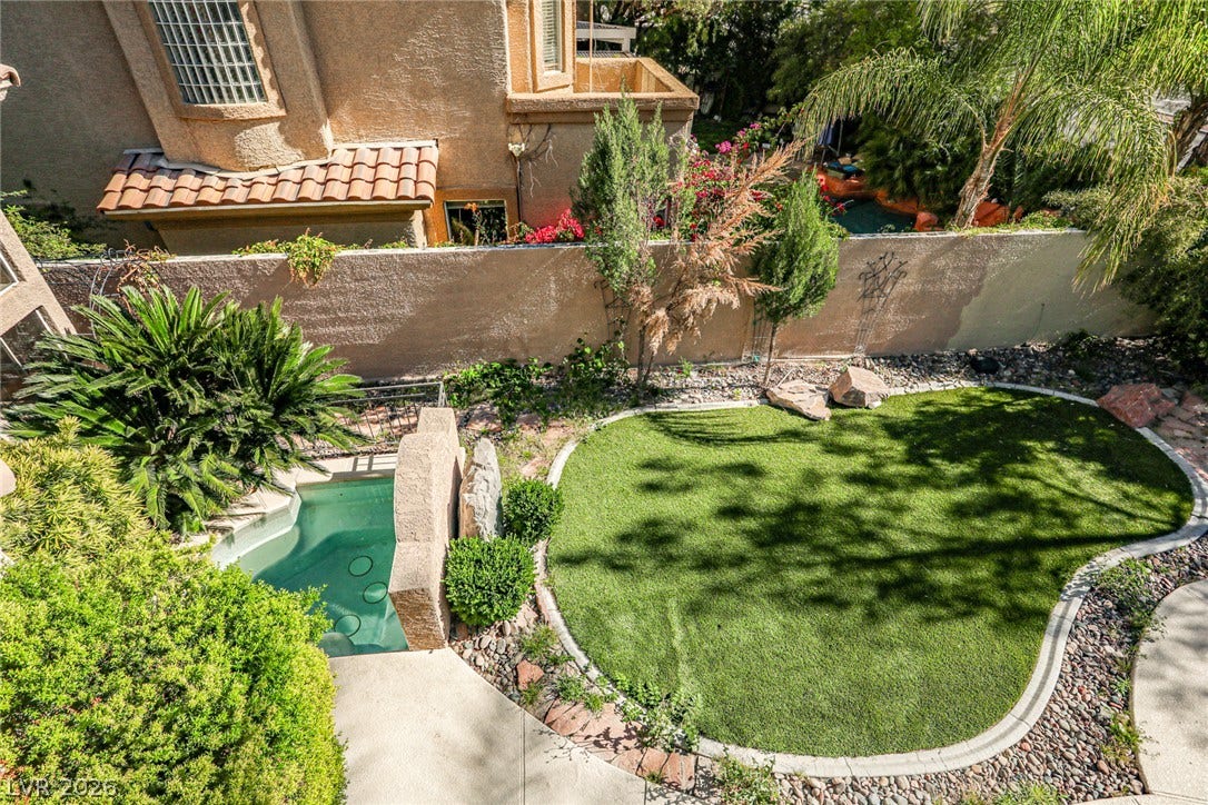 1828 Dolce Drive, Las Vegas, NV 89134 A tranquil backyard oasis featuring a lush, artificial turf lawn and a refreshing swimming pool.