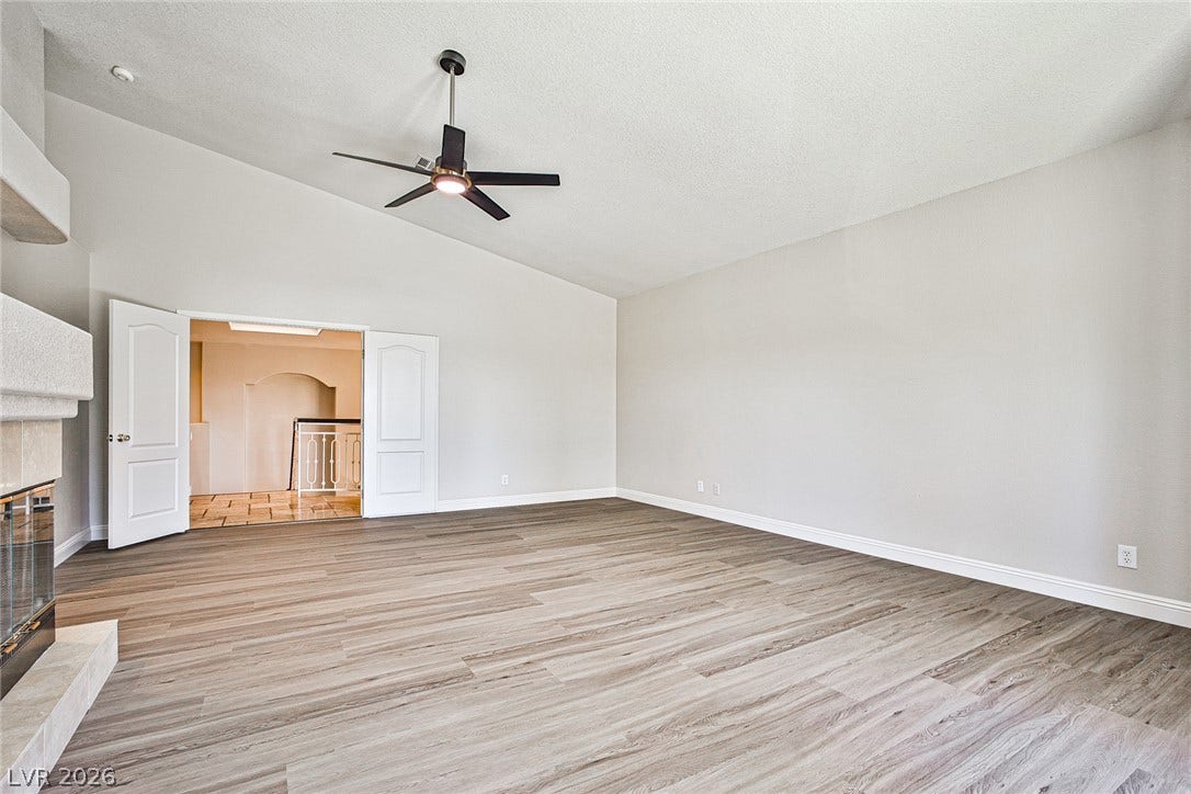 1828 Dolce Drive, Las Vegas, NV 89134 A spacious living area features vaulted ceilings, light wood-look flooring, and a welcoming fireplace.