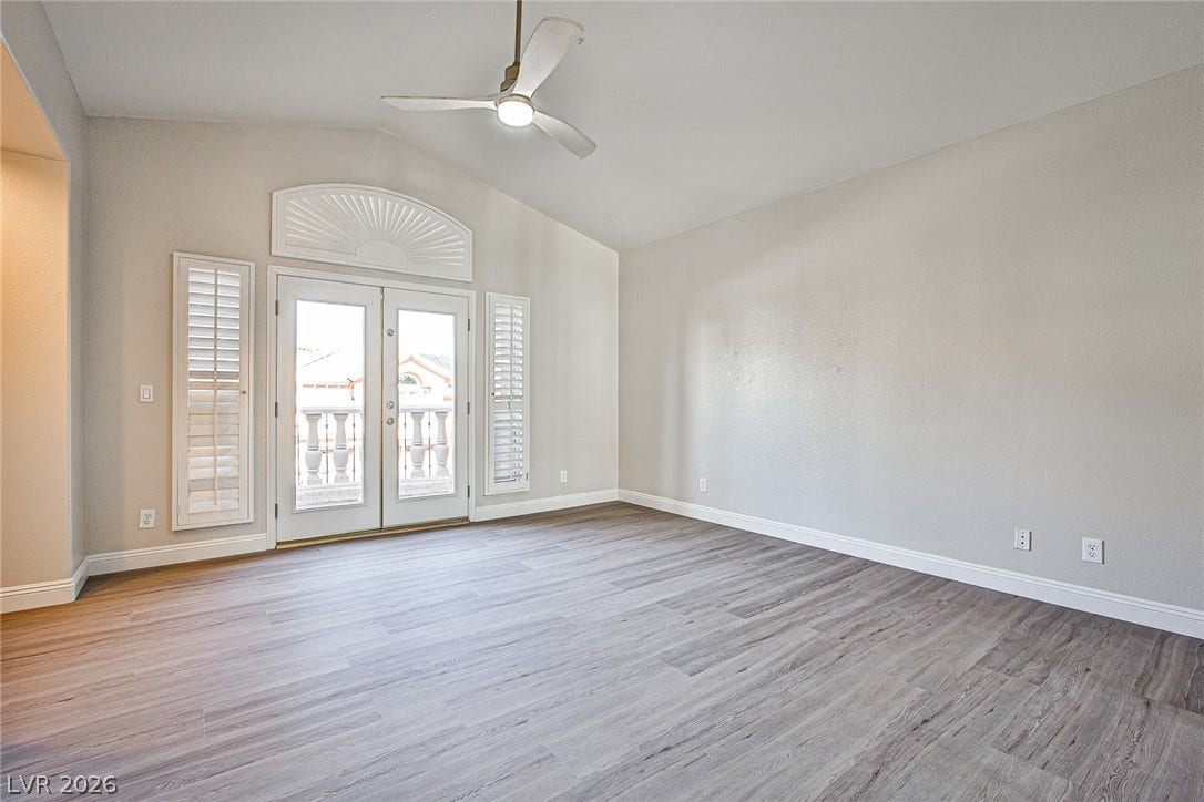 1828 Dolce Drive, Las Vegas, NV 89134 French doors open to an outdoor balcony, extending this versatile room with vaulted ceilings and light wood flooring.