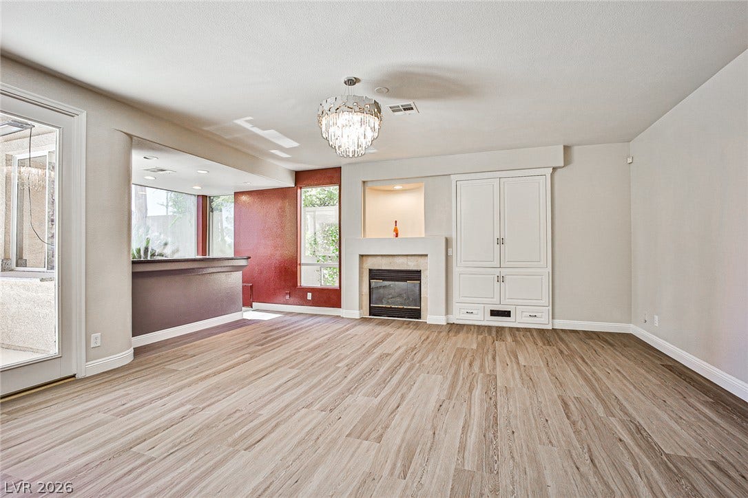 1828 Dolce Drive, Las Vegas, NV 89134 A refined living space showcasing a contemporary fireplace with elegant built-in cabinetry and durable flooring.