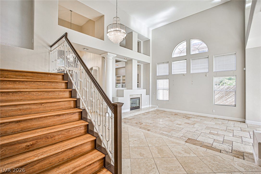 1828 Dolce Drive, Las Vegas, NV 89134 A grand entryway features soaring ceilings, a sweeping staircase, and a contemporary fireplace.