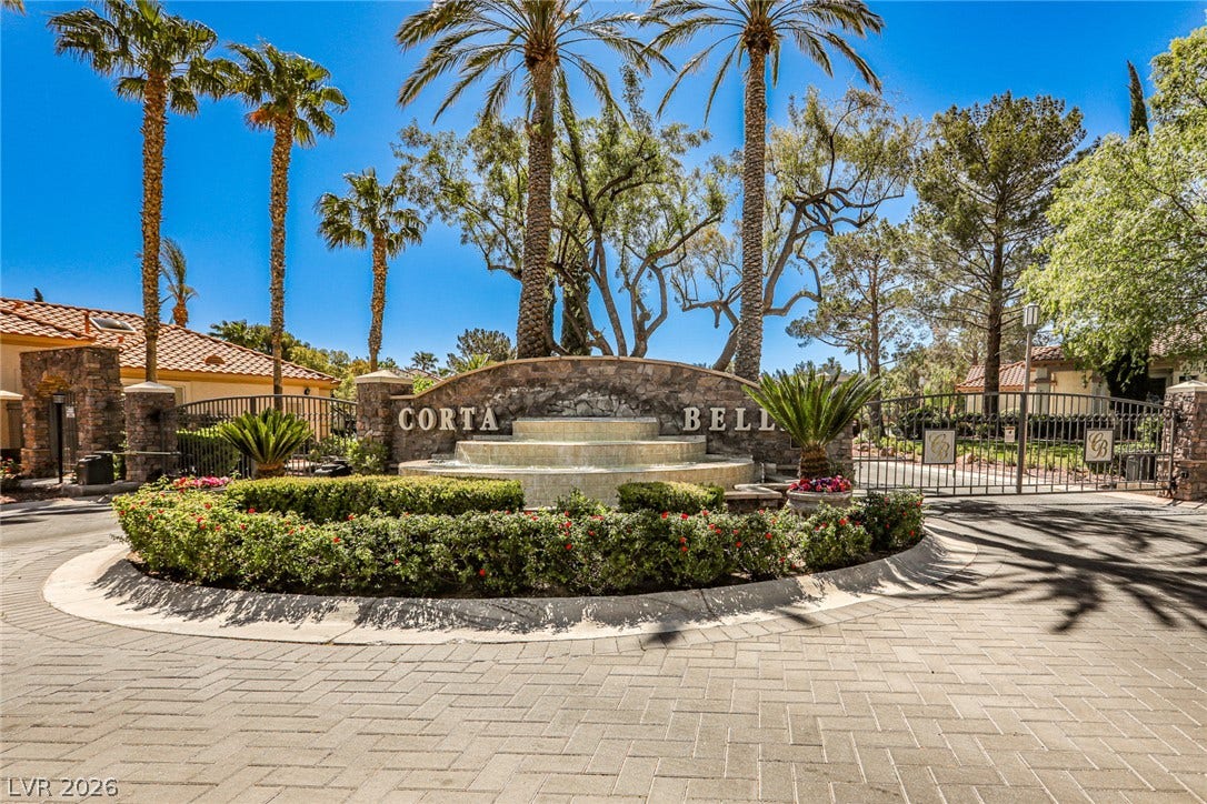1828 Dolce Drive, Las Vegas, NV 89134 A grand gated entrance welcomes residents with a multi-tiered fountain and lush landscaping.
