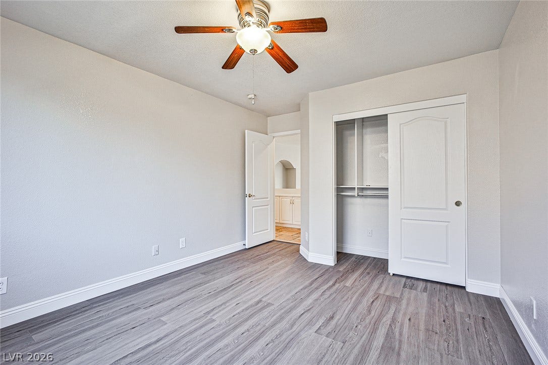 1828 Dolce Drive, Las Vegas, NV 89134 A quiet bedroom, freshly updated, offers comfort and simplicity with a dedicated closet and a ceiling fan.
