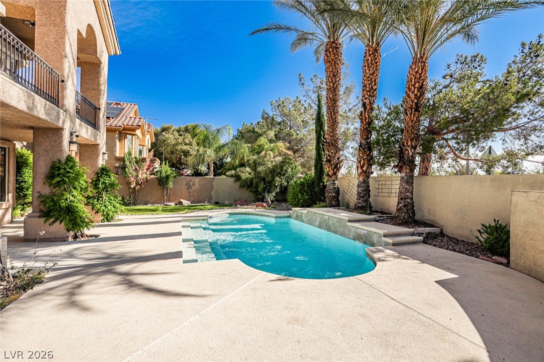 1828 Dolce Drive, Las Vegas, NV 89134 A tranquil backyard oasis features a glistening pool, ideal for relaxation and outdoor enjoyment.