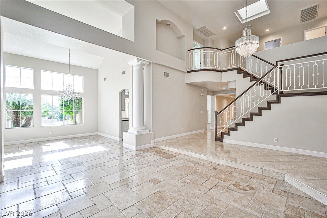 1828 Dolce Drive, Las Vegas, NV 89134 A grand entrance welcomes all with towering windows, lustrous tiled floors, and a sweeping staircase.
