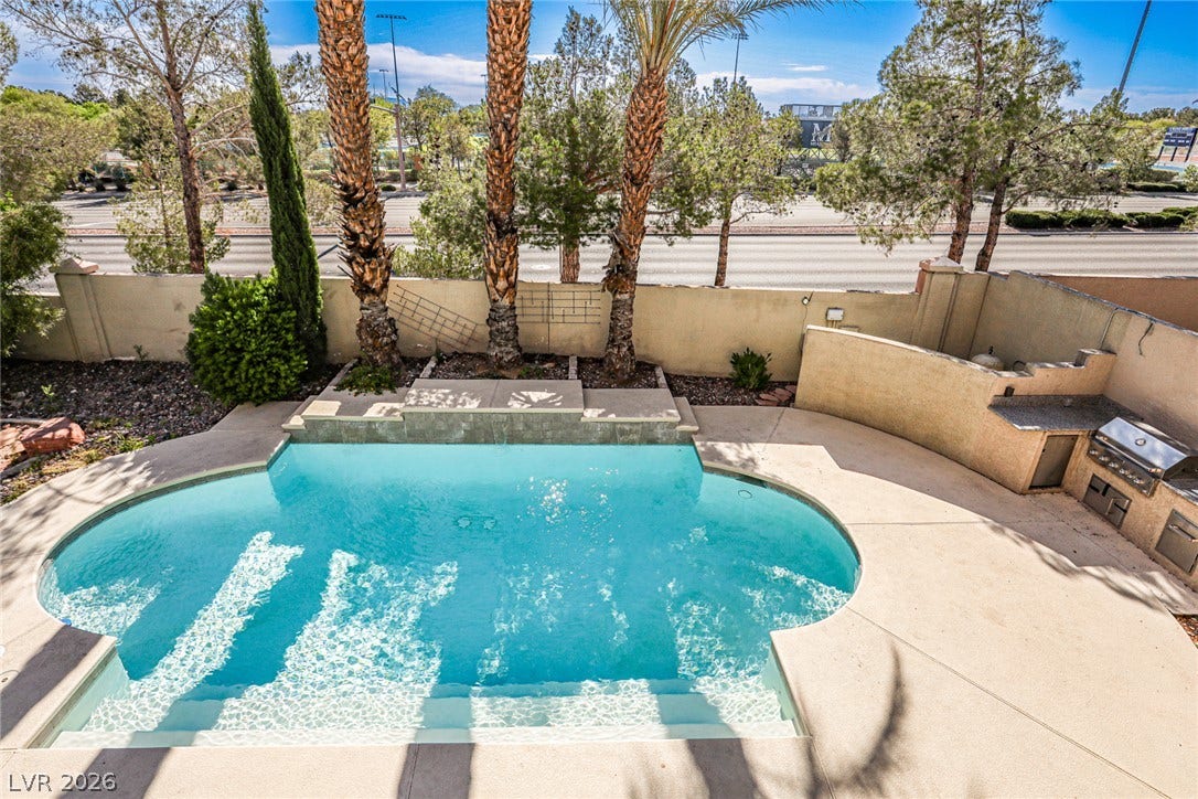 1828 Dolce Drive, Las Vegas, NV 89134 An inviting swimming pool and outdoor kitchen create a personal oasis.