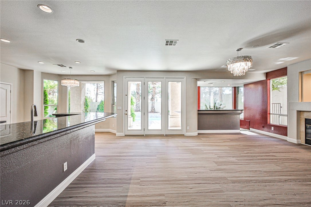 1828 Dolce Drive, Las Vegas, NV 89134 An open concept living area boasts a sleek breakfast bar and direct access to the outdoor patio through elegant French doors.