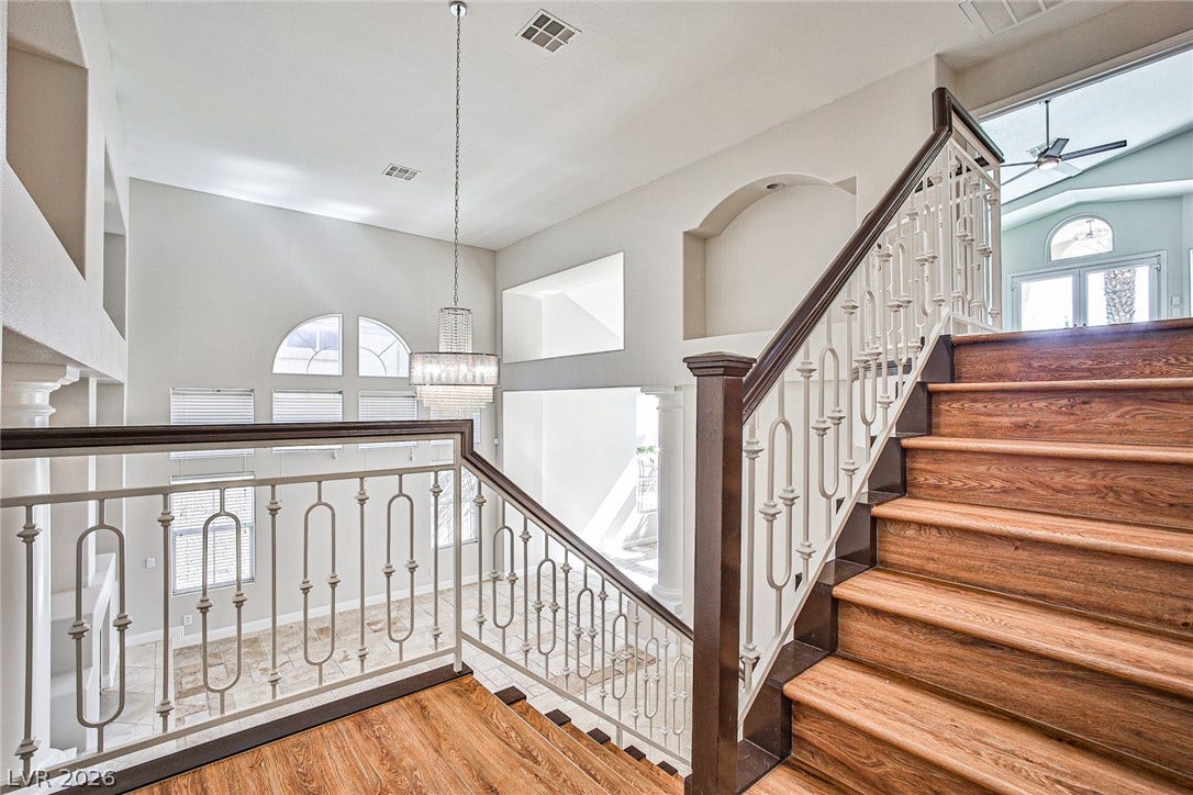 1828 Dolce Drive, Las Vegas, NV 89134 Elegant hardwood staircase with ornate railings gracefully ascends to the upper level.