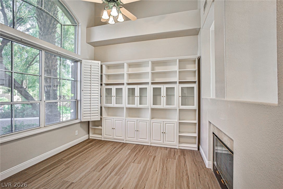 1828 Dolce Drive, Las Vegas, NV 89134 Tall windows and integrated shelving define this airy, light-filled living space with a charming fireplace.