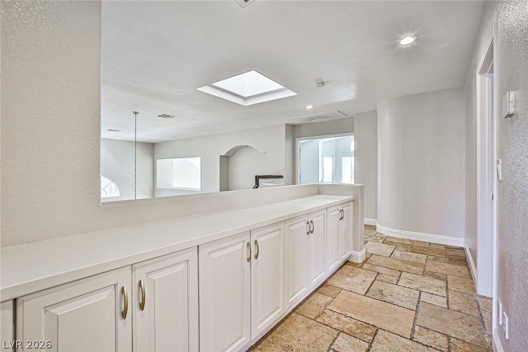 1828 Dolce Drive, Las Vegas, NV 89134 A well-lit landing features integrated storage cabinetry and a view to the main living area below.