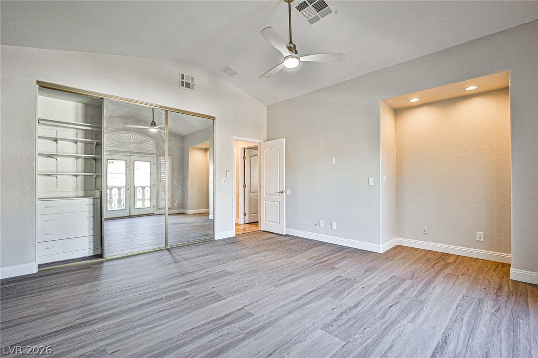 1828 Dolce Drive, Las Vegas, NV 89134 Vast, naturally illuminated bedroom with a dedicated display nook and mirrored closet doors enhancing its volume.
