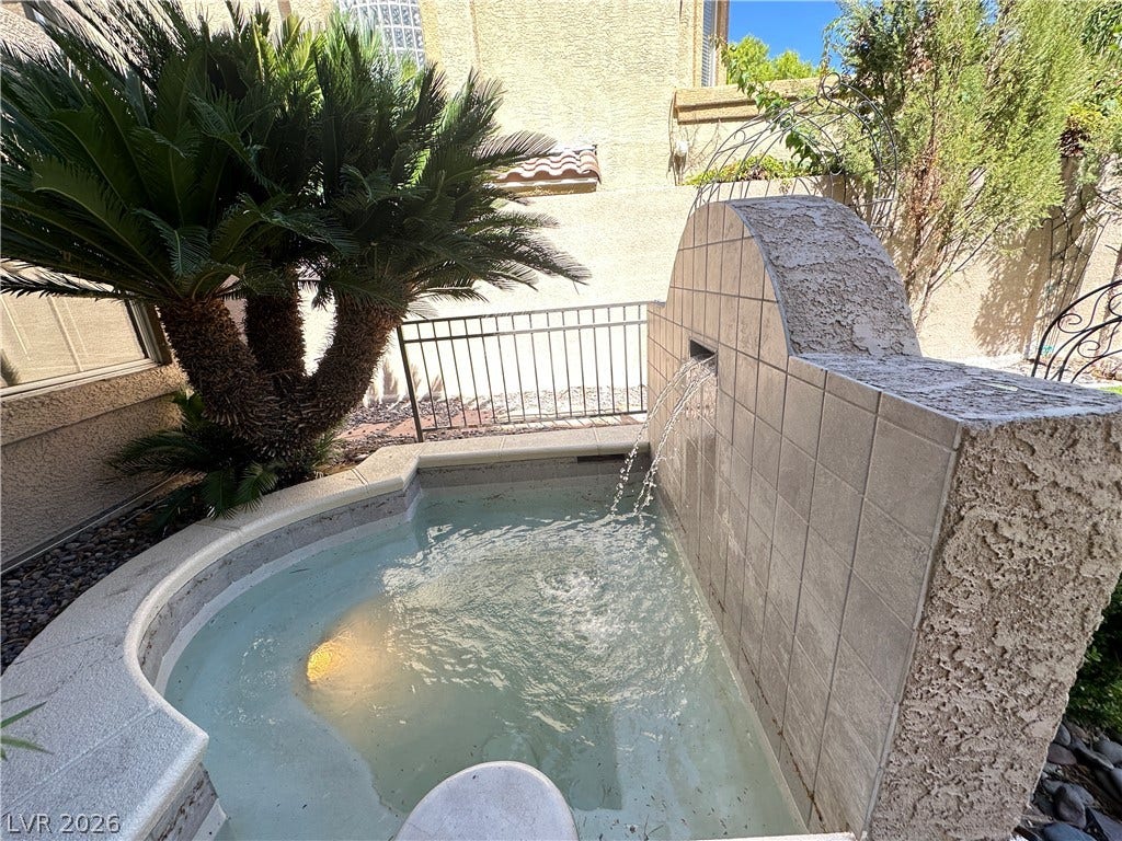 1828 Dolce Drive, Las Vegas, NV 89134 An inviting private spa with a tranquil waterfall feature and lush landscaping.