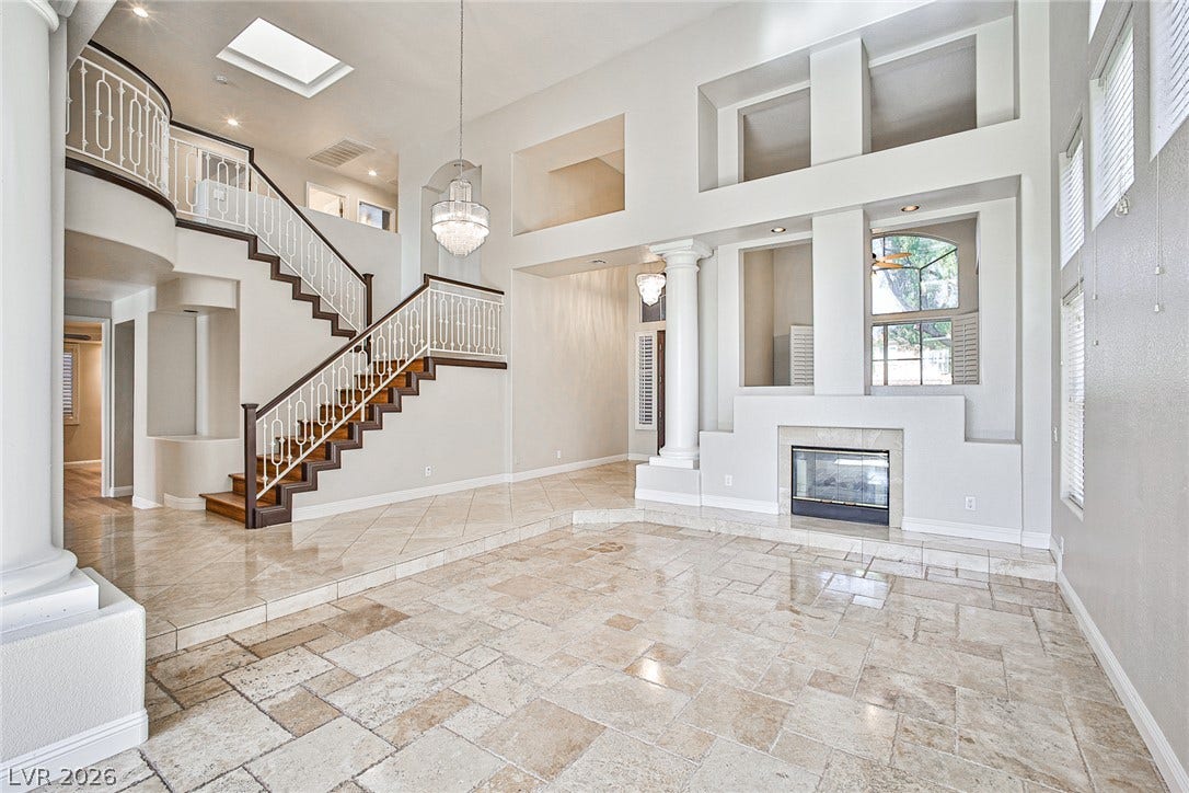 1828 Dolce Drive, Las Vegas, NV 89134 Grand two-story living area features a majestic staircase and a cozy fireplace.