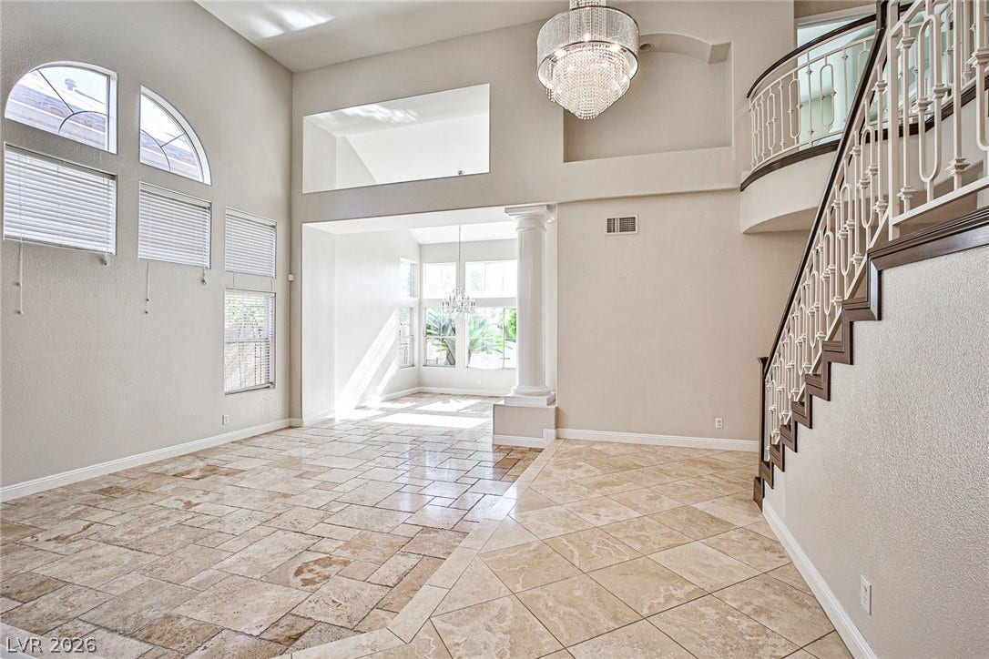 1828 Dolce Drive, Las Vegas, NV 89134 A grand entry with soaring ceilings, a dazzling chandelier, and a graceful curved staircase welcomes all.