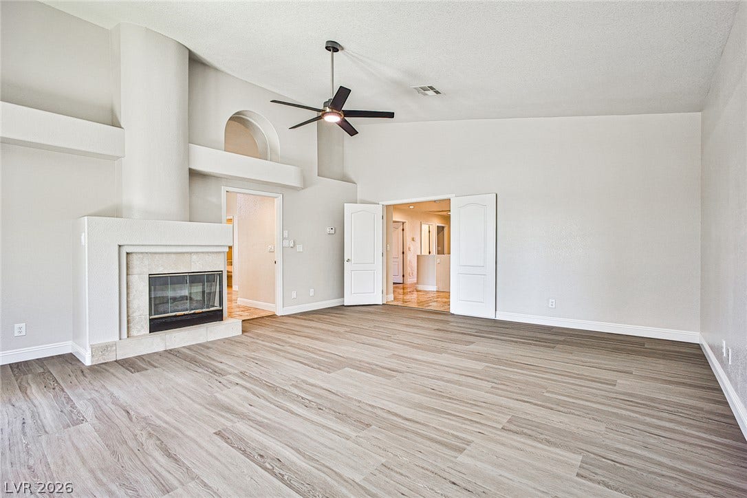 1828 Dolce Drive, Las Vegas, NV 89134 A spacious living area offers vaulted ceilings and a cozy fireplace, perfect for gatherings.