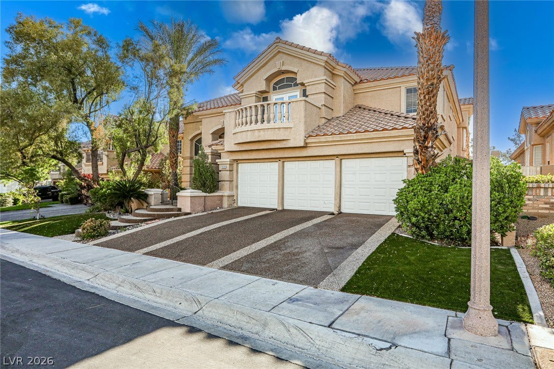 1828 Dolce Drive, Las Vegas, NV 89134 Three garage doors provide ample parking for this elegant two-story stucco residence.
