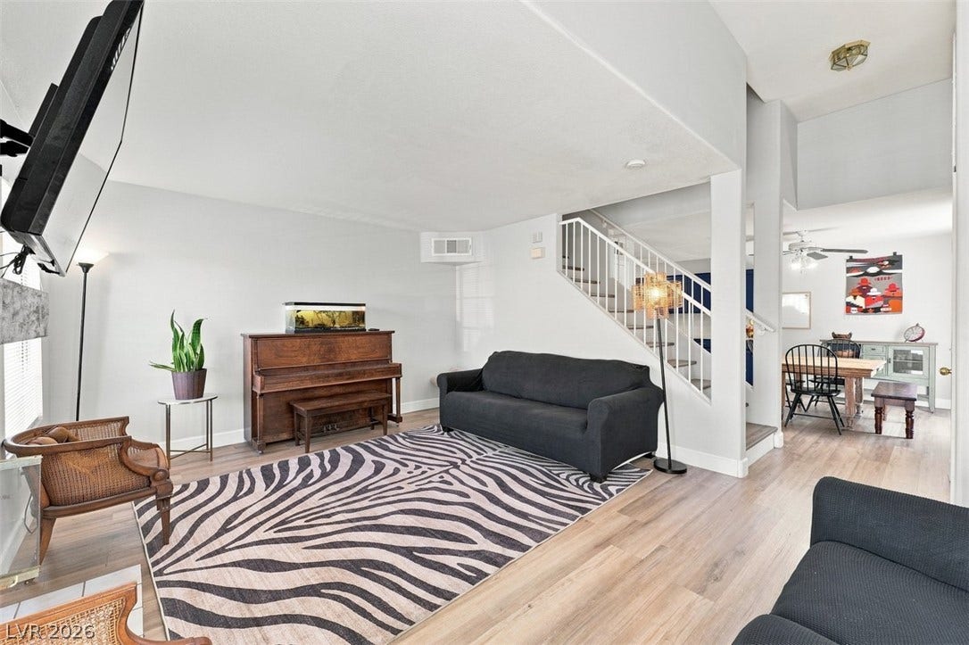 505 Rafkin Place, Henderson, NV 89052 A well-lit interior space features sleek light wood flooring, an open-concept layout, and a convenient staircase leading to the upper level.