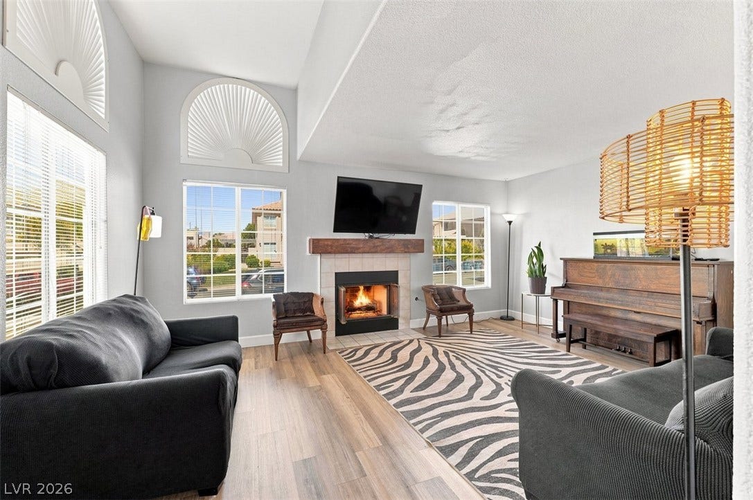 505 Rafkin Place, Henderson, NV 89052 A welcoming living area featuring a cozy fireplace, abundant natural light, and elegant wood flooring.