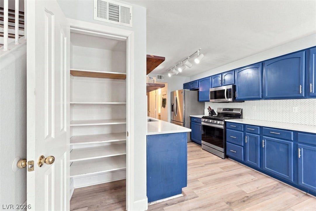 505 Rafkin Place, Henderson, NV 89052 Ample pantry storage and sleek blue cabinetry elevate this well-appointed kitchen.