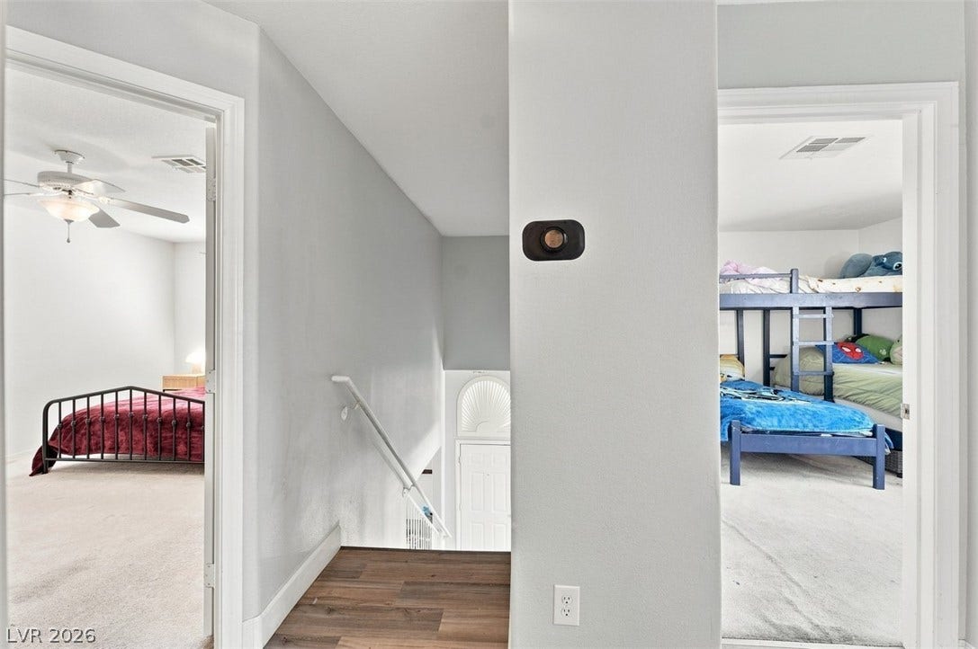 505 Rafkin Place, Henderson, NV 89052 Hallway featuring warm wood flooring leading to well-lit bedrooms and a view of the staircase.
