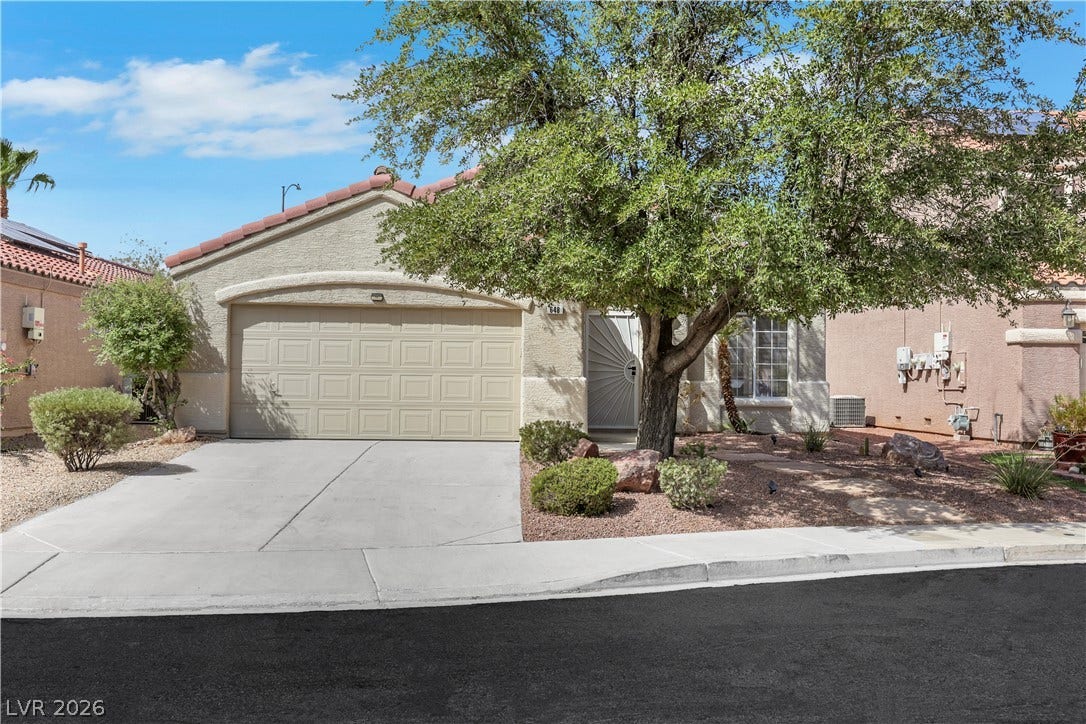 648 Moonlight Mesa Drive, Henderson, NV 89011 A well-maintained stucco facade with an attached garage and mature tree enhance this inviting residence.