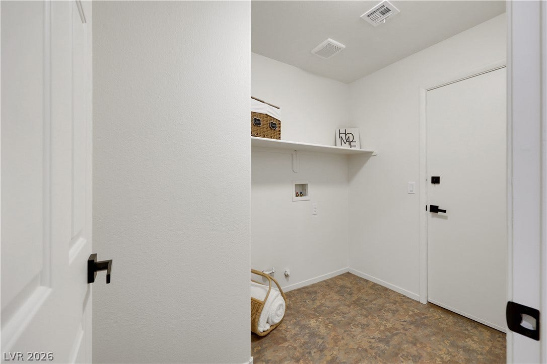 648 Moonlight Mesa Drive, Henderson, NV 89011 A dedicated laundry space offers convenience with wall shelving and durable flooring.