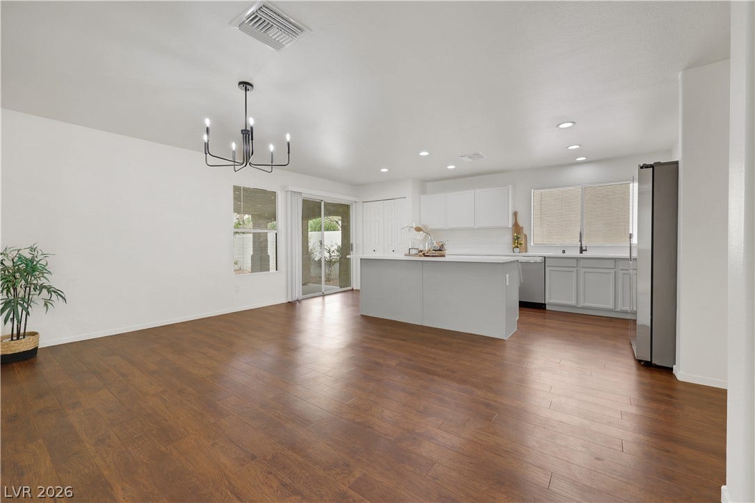 648 Moonlight Mesa Drive, Henderson, NV 89011 An open-concept living space presents warm wood flooring and a kitchen island with casual seating.